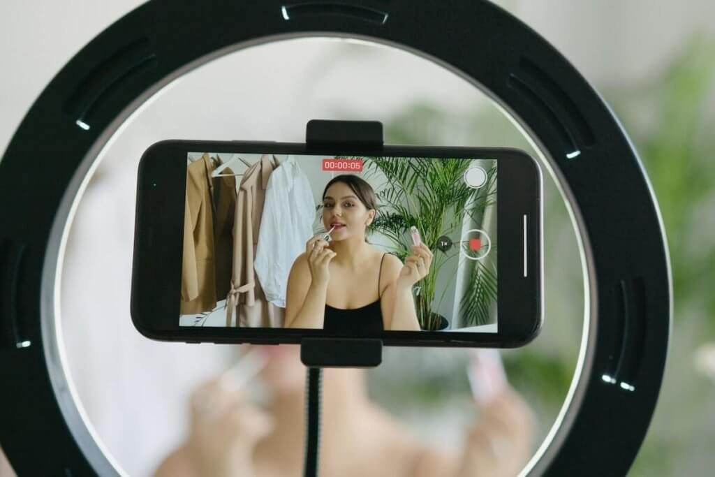 A Woman Putting Lip Tint in Front of Camera