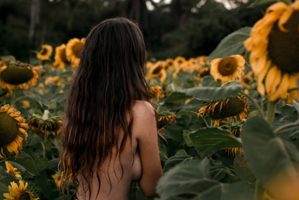 topless model in sunflower field