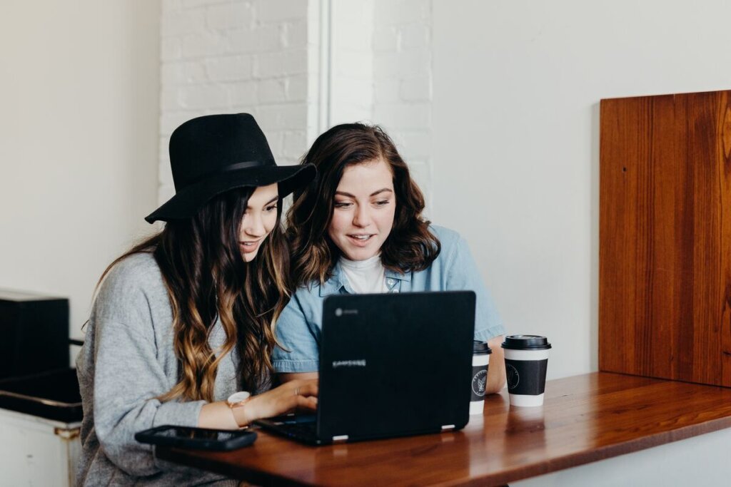 two girls staring at laptop
